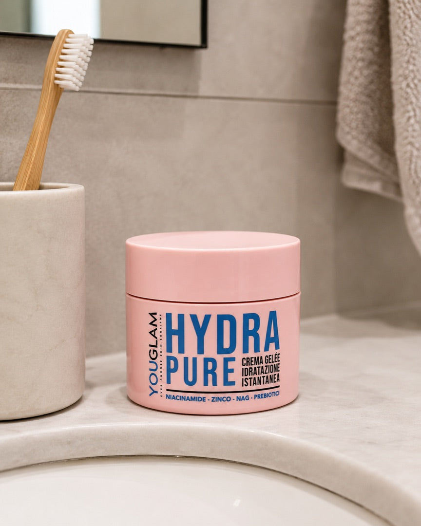 Il barattolo di HYDRAPURE appoggiato sul lavandino di un bagno accanto a uno spazzolino